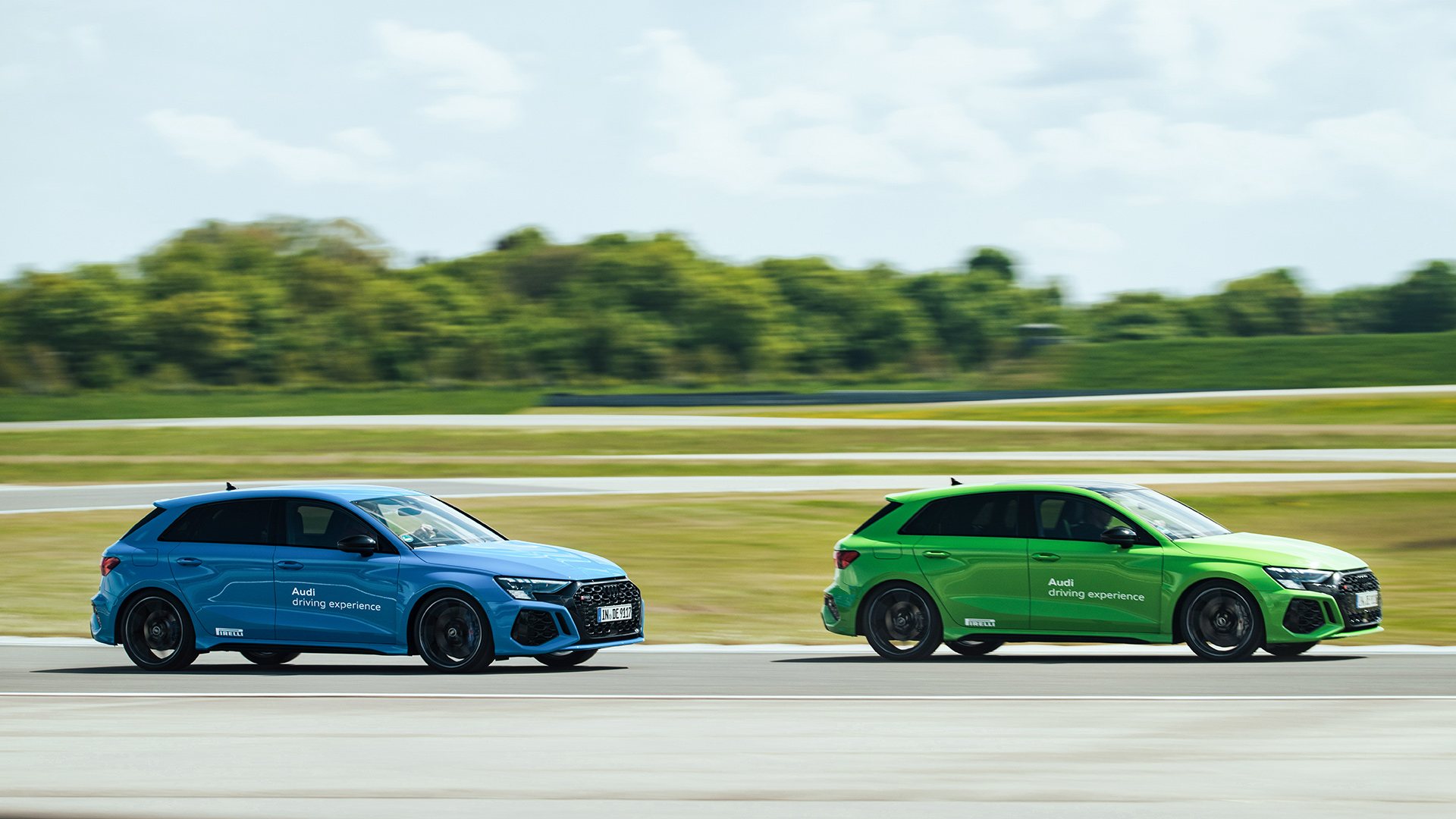 Blue and green Audi RS 3 Sportback drive one behind the other on the race track
