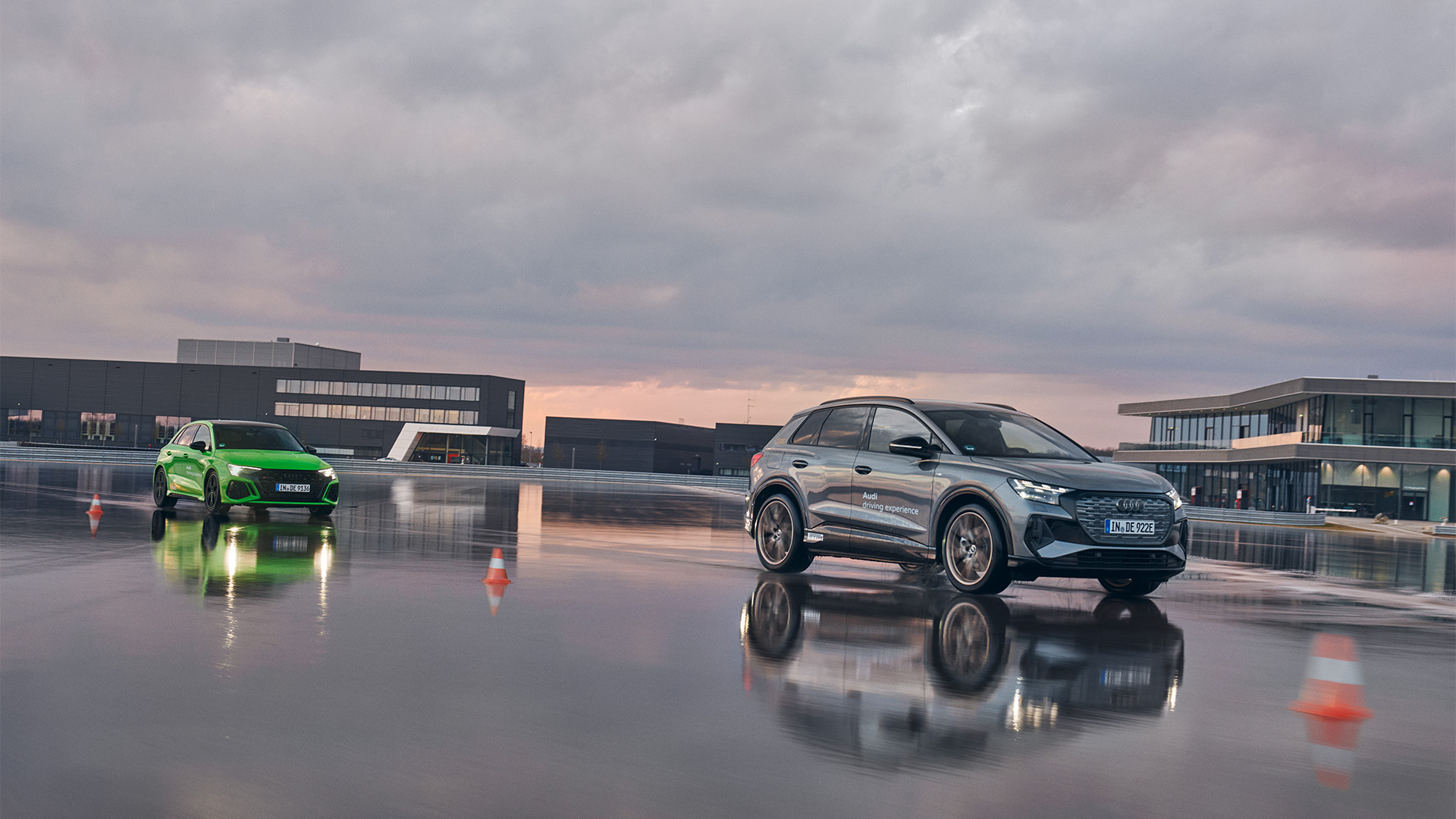 Green RS 3 Sportback and gray Q4 e-tron on wet roads