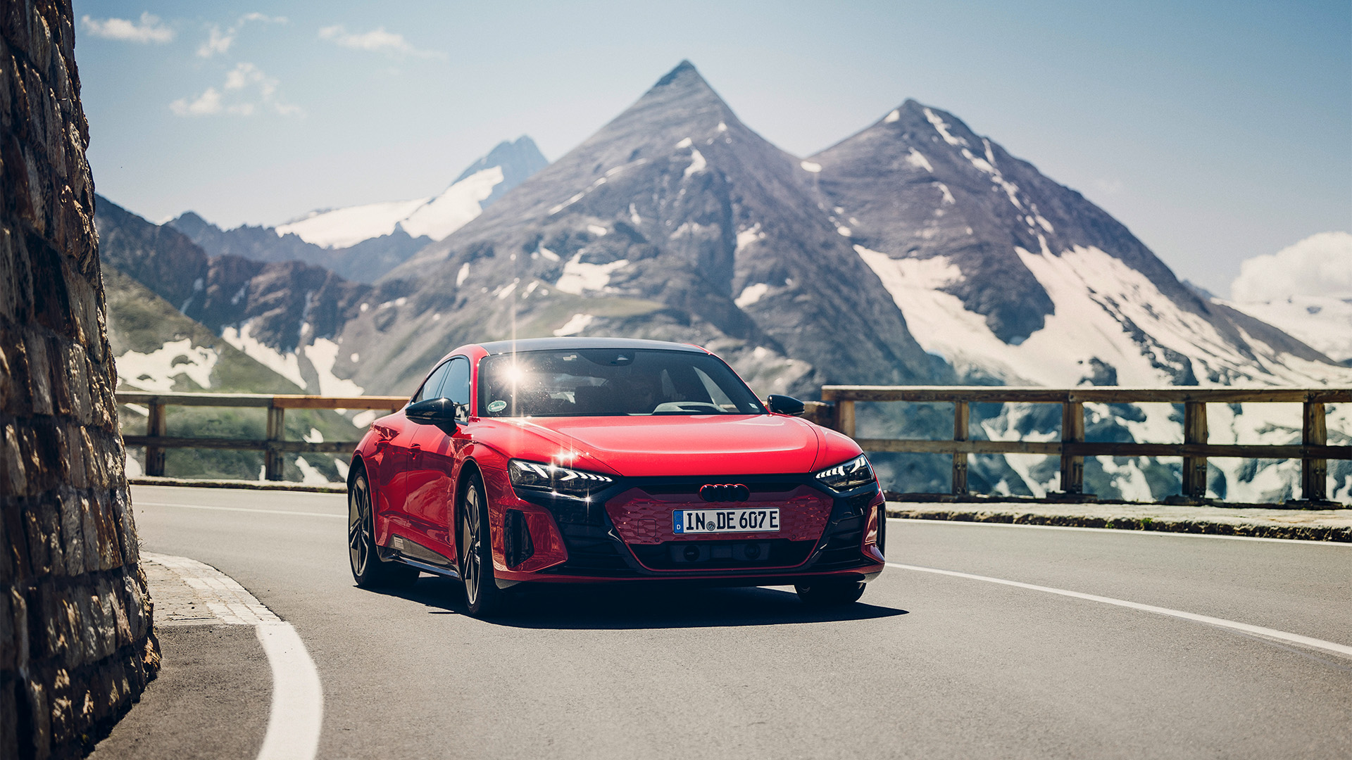 Red Audi RS e-tron GT drives through the mountains in great weather