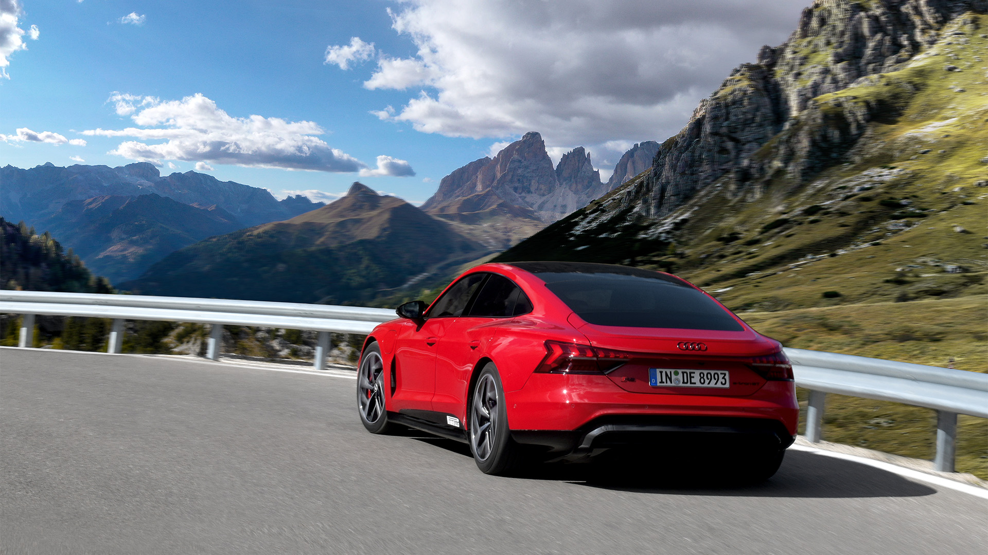Red Audi RS e-tron GT drives through the mountains in great weather