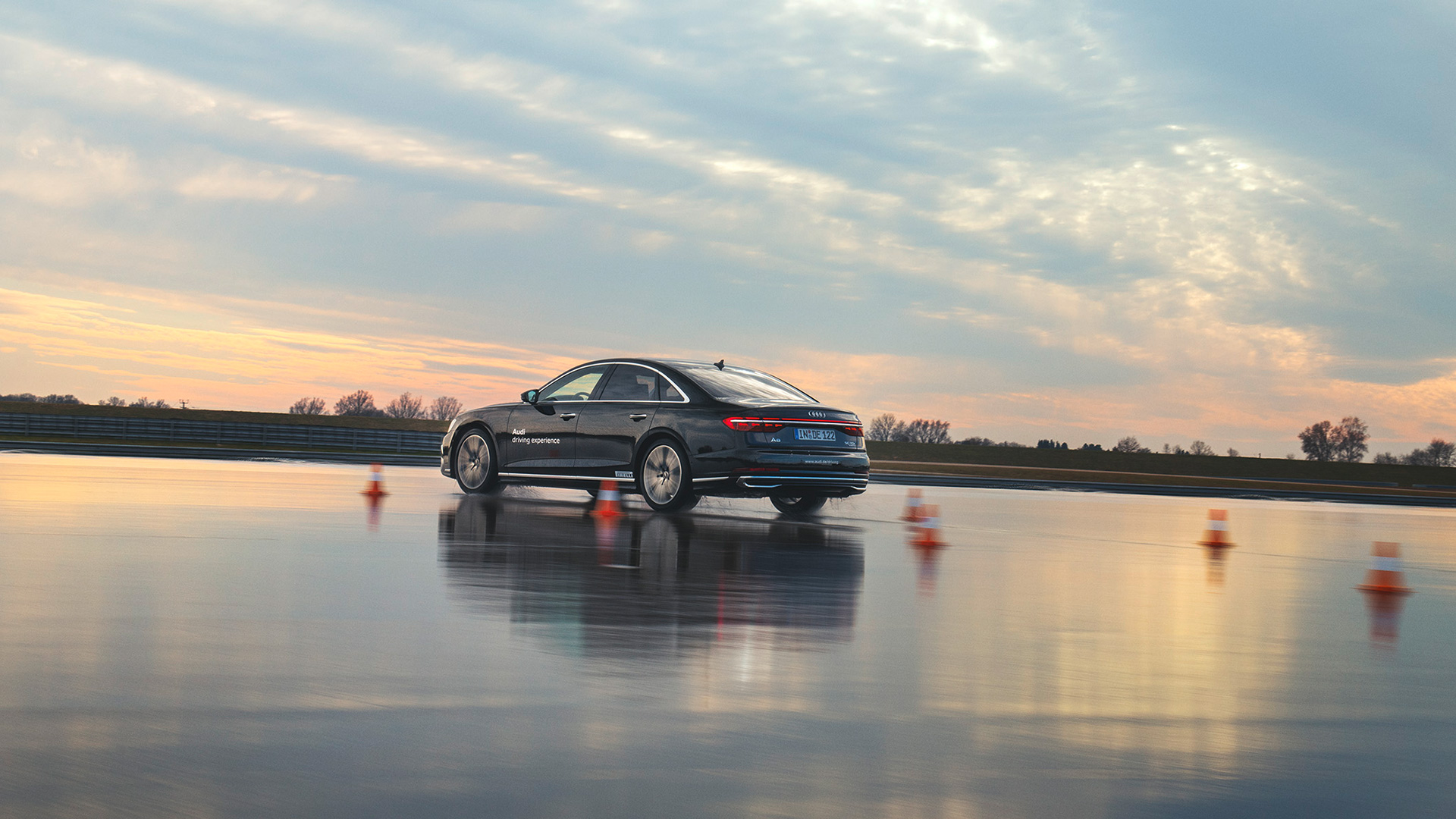 Black A8 50 TDI quattro doing parcour on a wet track during dawn