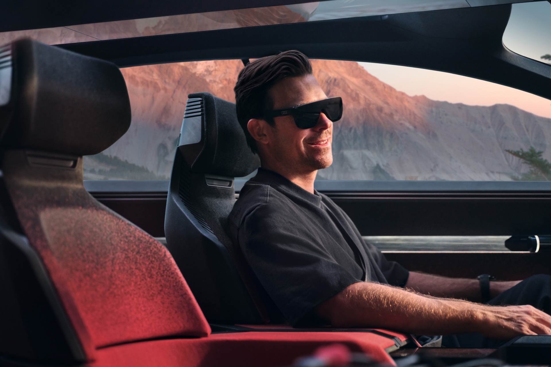 Hayden Cox sitzt im Audi activesphere concept und trägt eine AR-Brille.